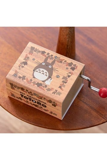 My Neighbor Totoro music box displayed on a wooden table with autumn leaf design and hand crank.