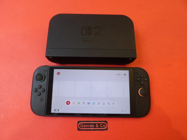Used Nintendo Switch 2 console with docking station and Joy-Con controllers on a red background.