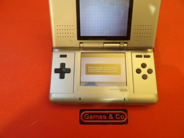 Nintendo DS console with charger displayed on a red background, featuring a dual-screen setup.