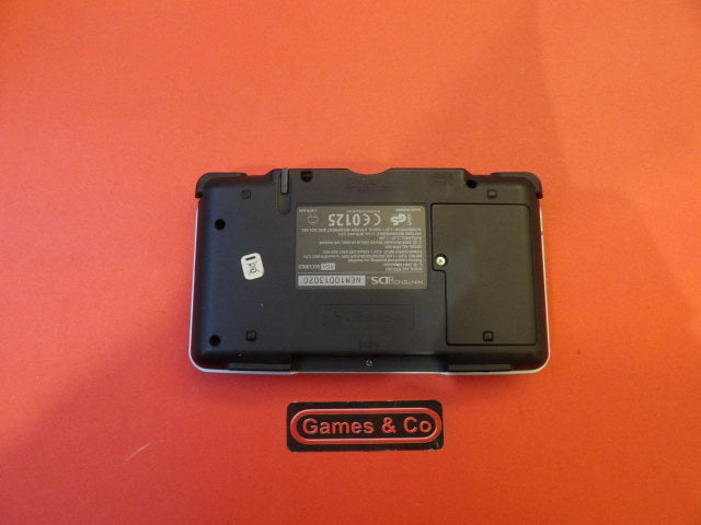 Nintendo DS console with charger displayed on a red background.