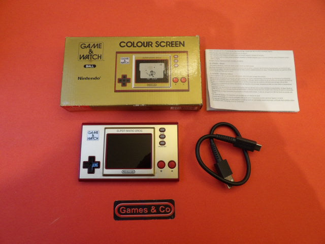 Nintendo Game & Watch Ball with colour screen and accessories on orange background.