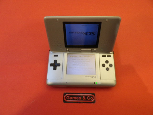 Nintendo DS console with charger displayed on a vibrant red background.