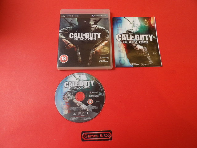 Call of Duty Black Ops Playstation 3 disc, game cover, manual, and disc displayed on red background.