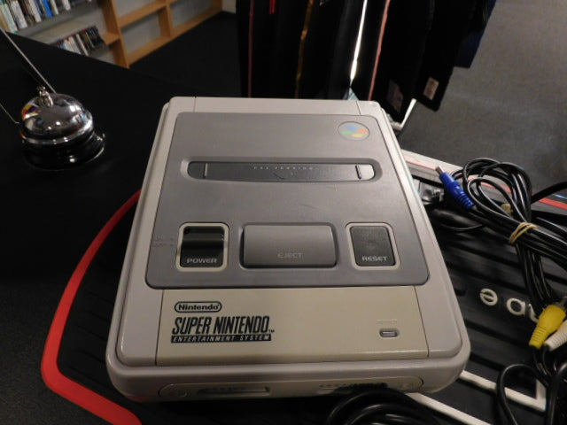 Used Super Nintendo console with power and reset buttons, bundled cables ready to play.