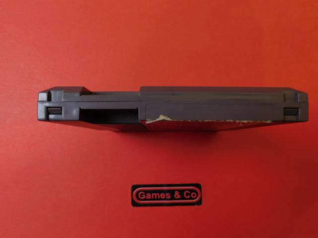 Snake's Revenge NES cartridge showing damaged label on the side against a bright background.