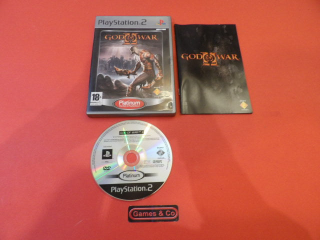 God of War II Playstation 2 game cover, disc, and booklet on a red background.