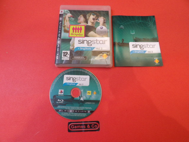 Singstar Vol.3 Playstation 3 disc alongside its case and manual on a red backdrop.