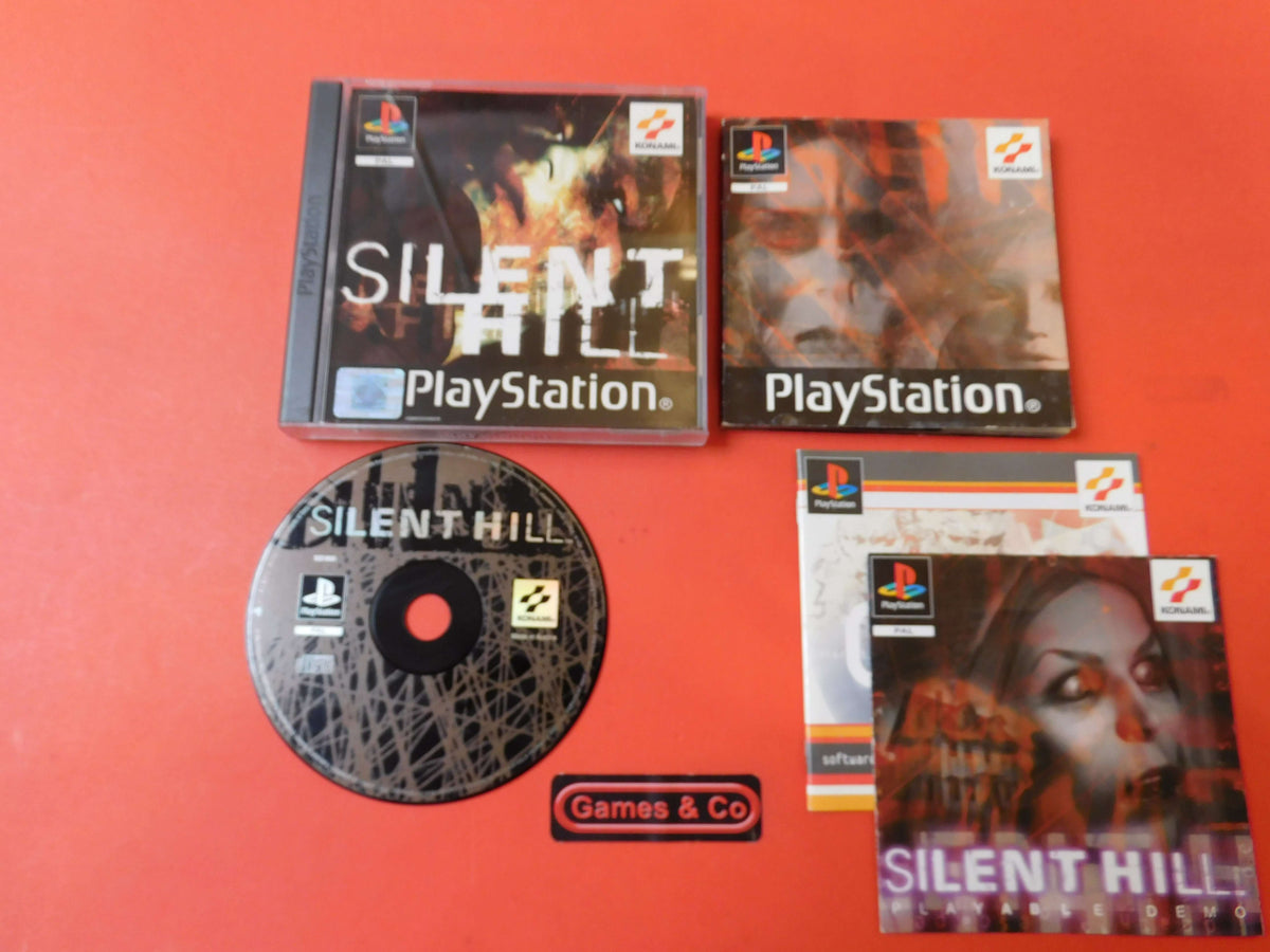 Silent Hill - Playstation 1 game disc and booklets displayed against a red background.