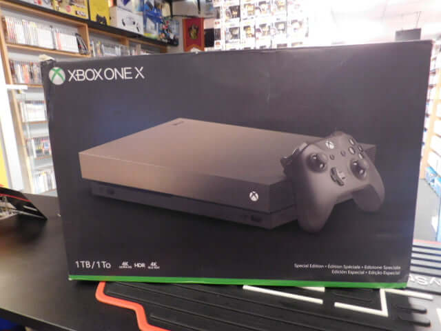 Xbox One X Console 1 TB, console packaging with original controller and cables, gaming equipment.